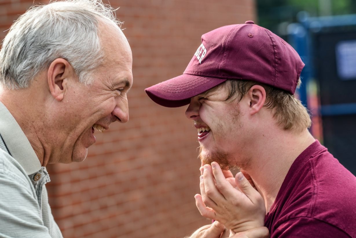 Boy with Down syndrom and an old man having fun together