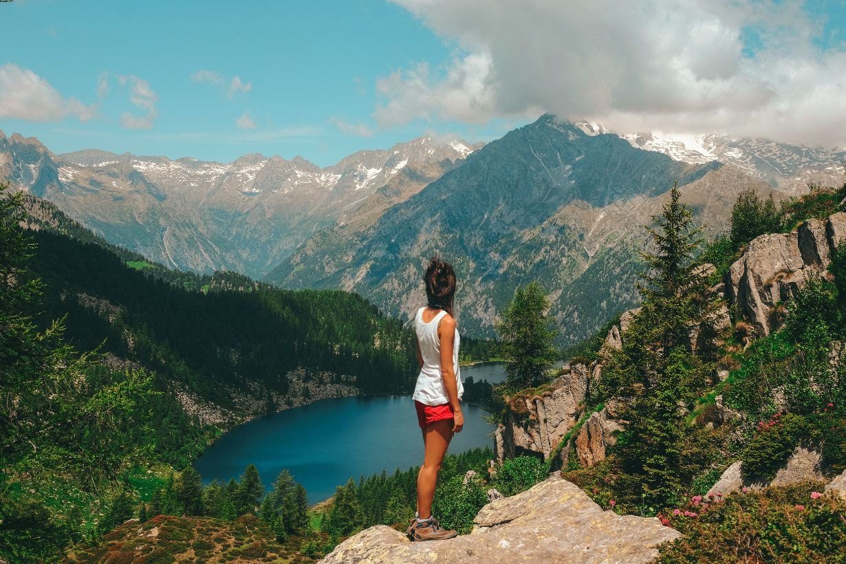 Young lady carer enjoying the beautiful mountains and lake below