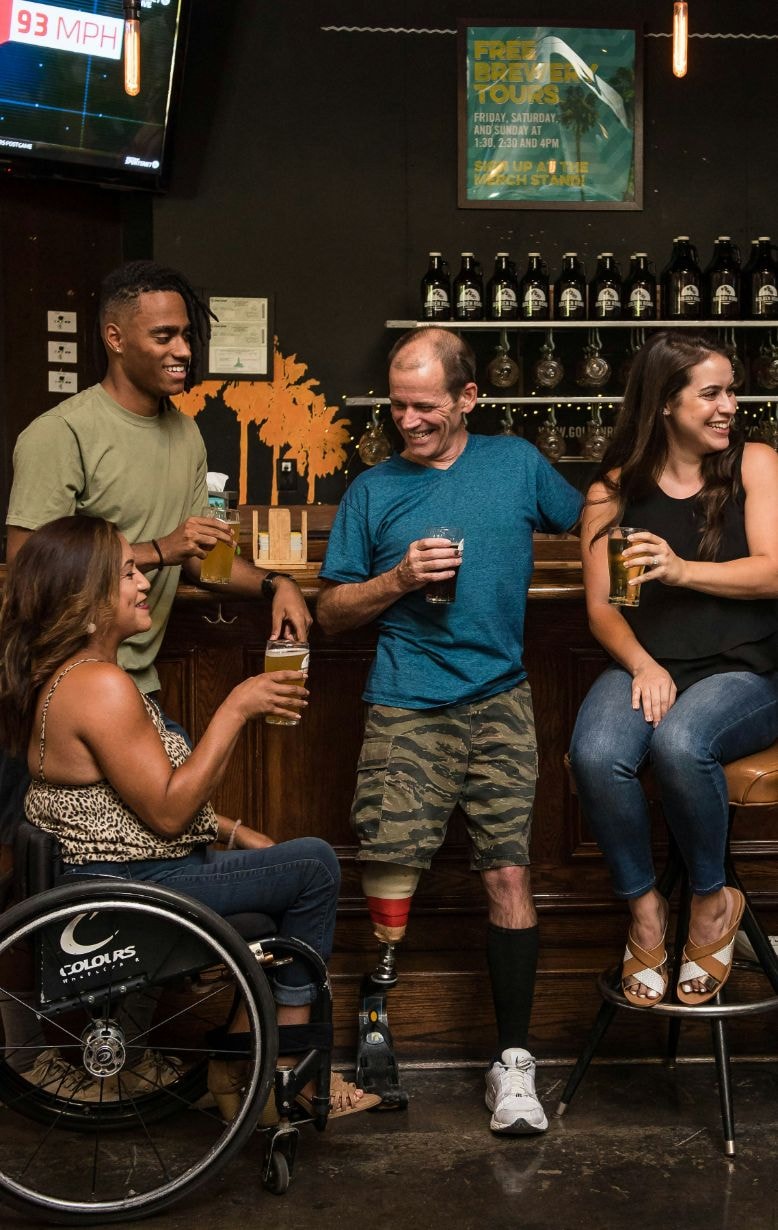 Young woman in her wheel chair and others enjoying at a pub