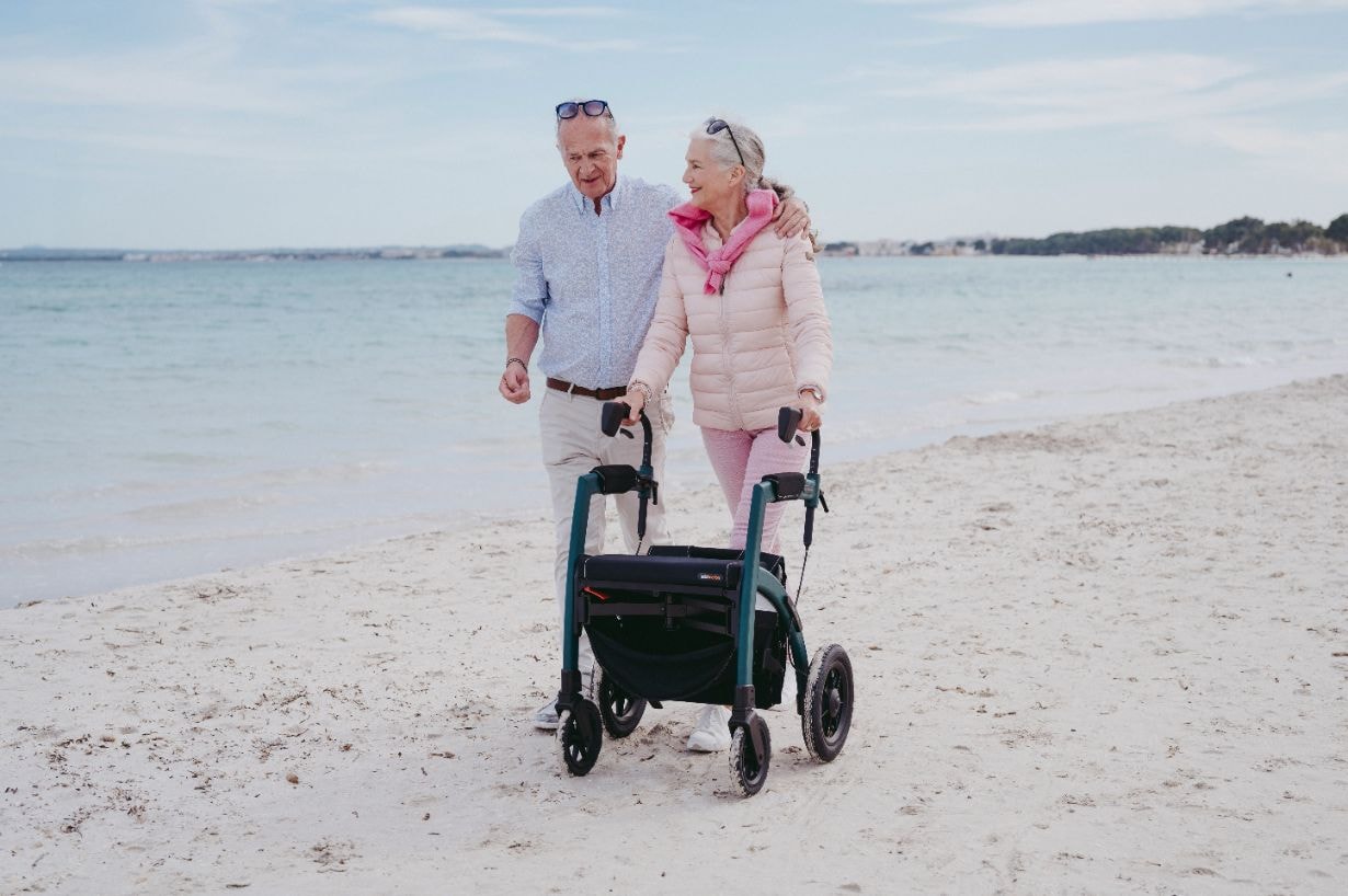 Disabled lady on a holiday using the walker on the sea beach