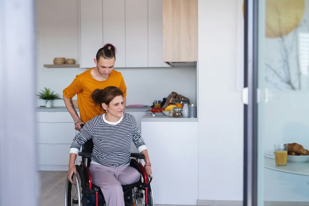 Caregiver assisting disabled woman with her wheelchair