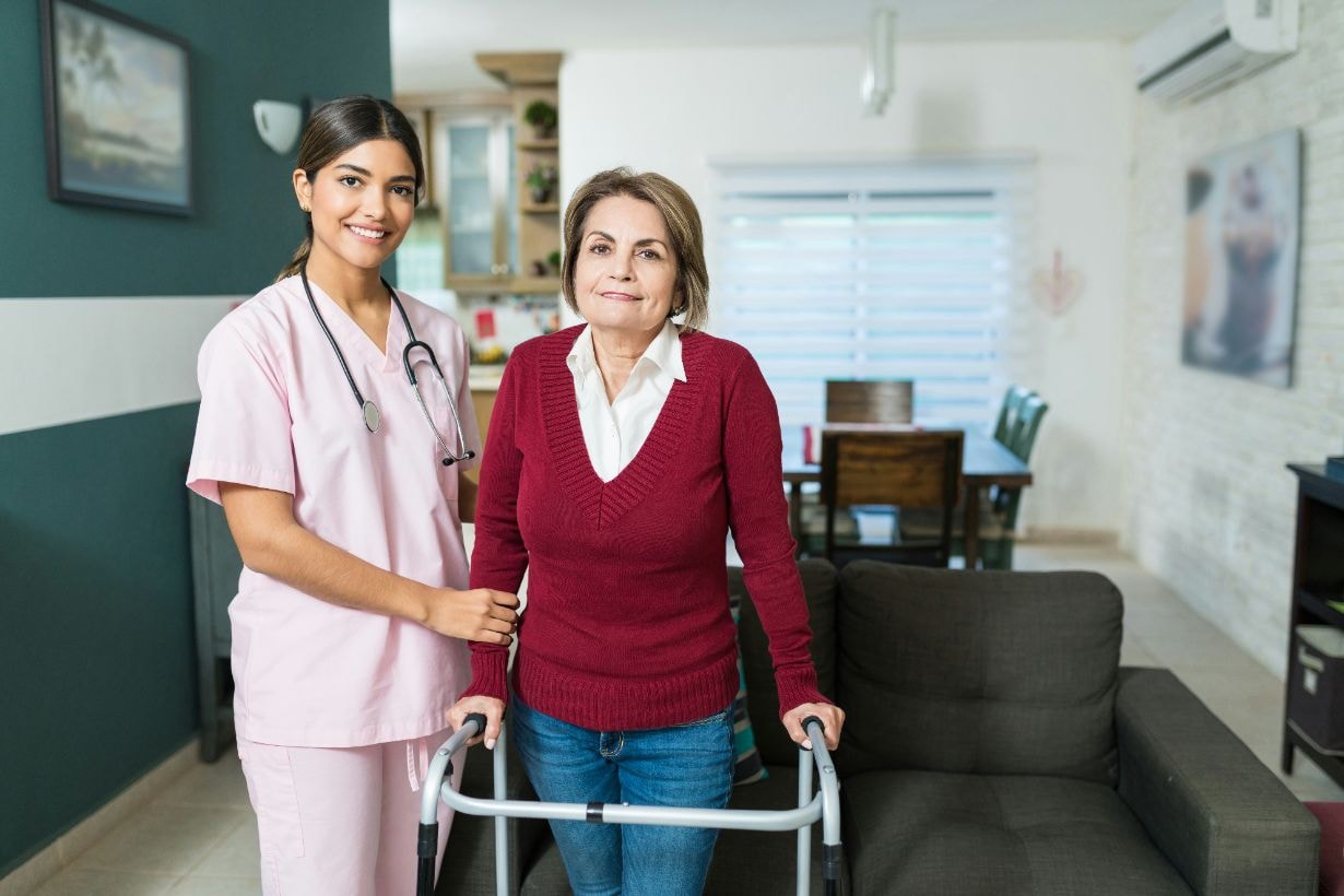 Caregiver helping disabled woman to walk using her crutches