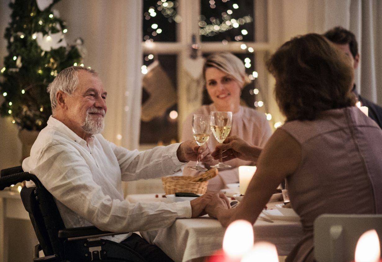 Old man enjoying Christmas dinner with family and friends